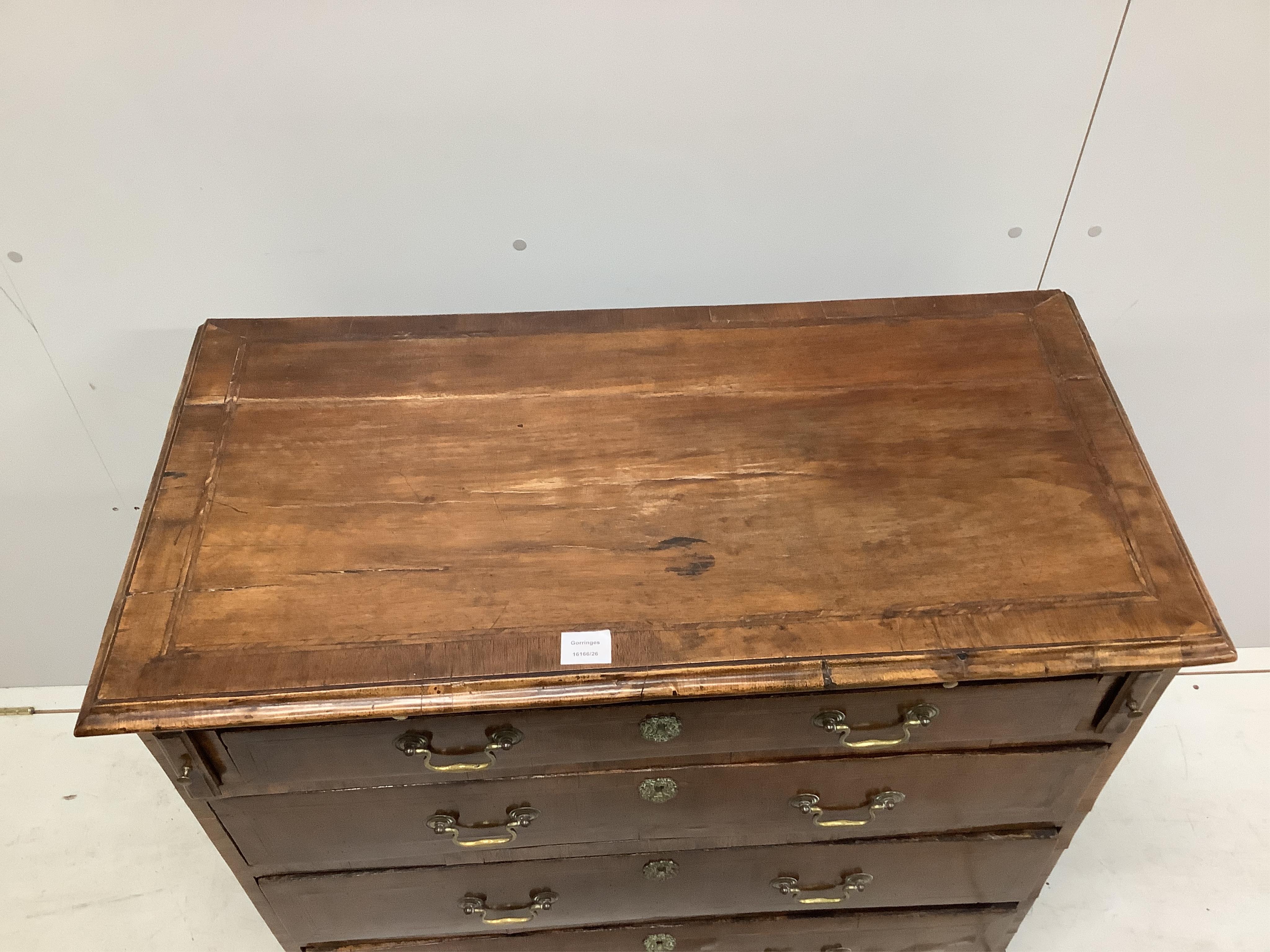 A mid 18th century feather banded walnut chest, fitted four long drawers, beneath a brushing slide, width 92cm, depth 48cm, height 92cm. Condition - fair